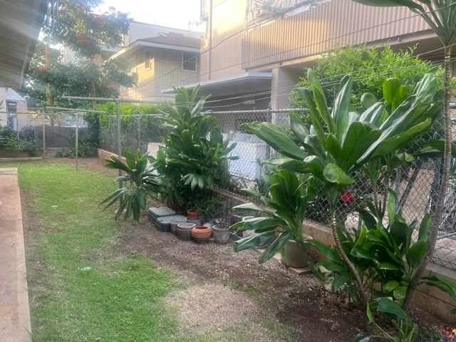 a yard with a fence and some plants